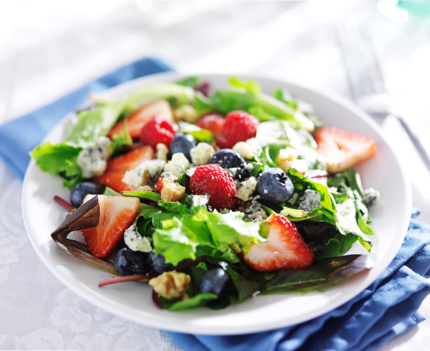berry salad with walnuts and blue cheese on white table cloth