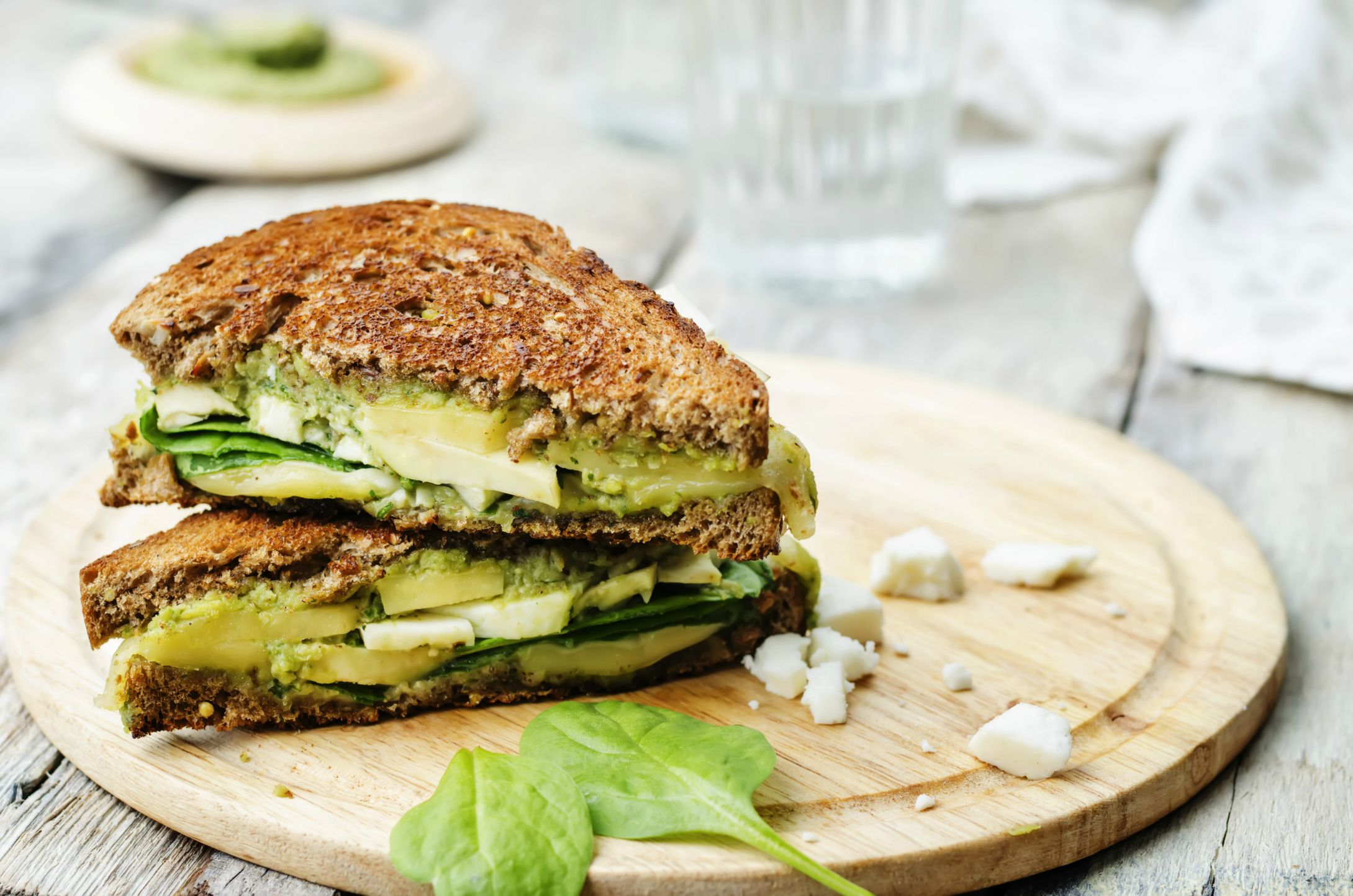 grilled rye sandwiches with cheese, spinach, pesto, avocado and goat cheese. the toning. selective focus