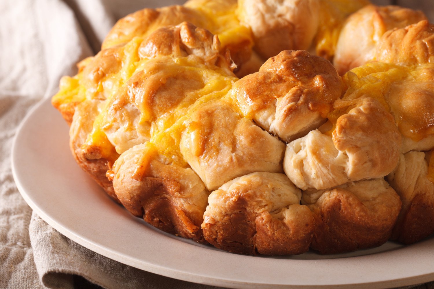Cheese-topped pull-apart monkey bread on plate