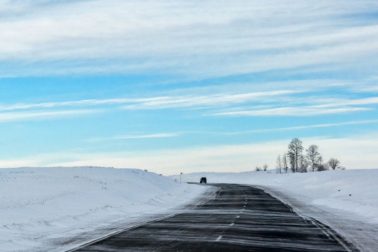 winter road in the Russian steppe, snow drifting