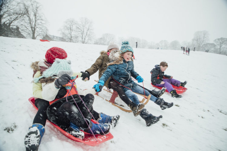 kids sledding in snow
