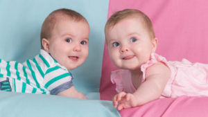 baby boy and girl on blue and pink backgrounds