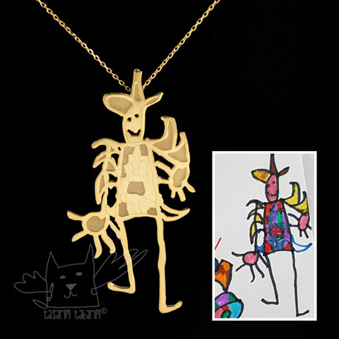 gold necklace on black background superimposed next to child's drawing