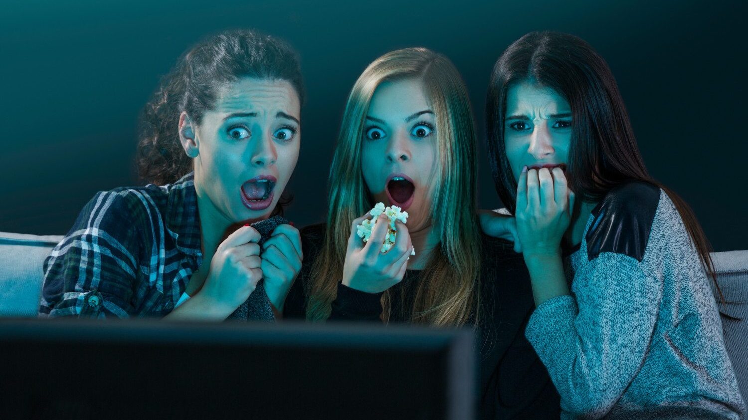 Scared teens watch horror on TV
