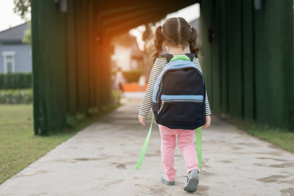 Small child with backpack walking to school