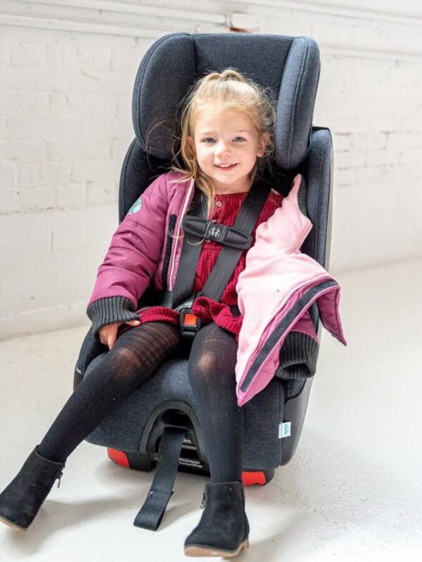 child wears special coat for car seats