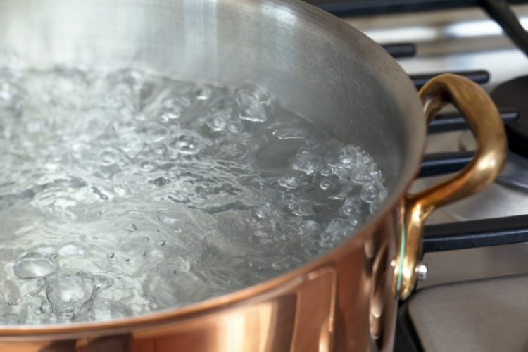 Brass pot of boiling water on stove