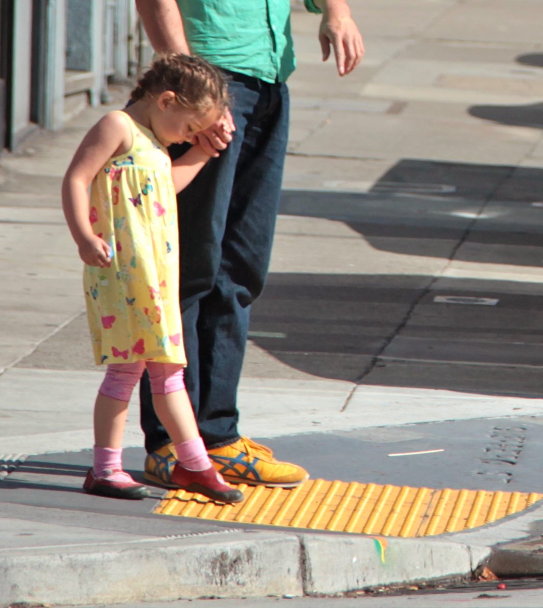 Child stepping on sidewalk bumps