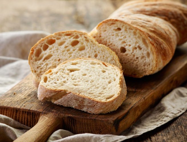 freshly baked ciabatta bread on wooden cutting board