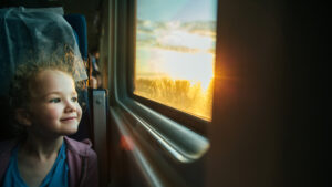 little girl looking out train window