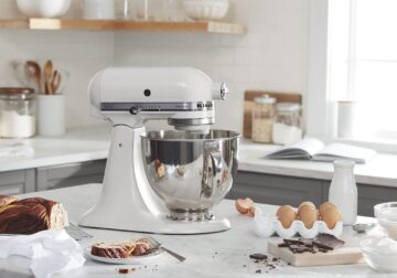 A kitchenaid stand mixer is surrounded by baking goods.