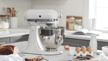 A kitchenaid stand mixer is surrounded by baking goods.