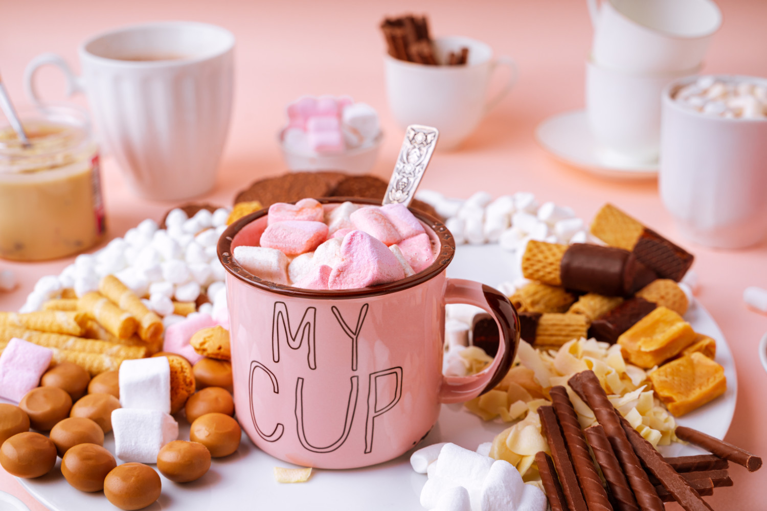 Hot chocolate in pink mug on charcuterie board