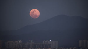 Pink supermoon rises over the horizon