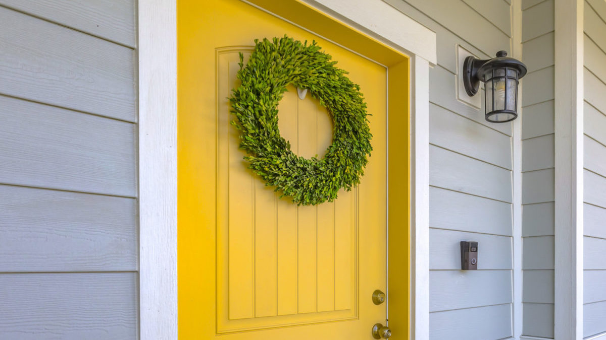 yellow front door of house with wreath on it