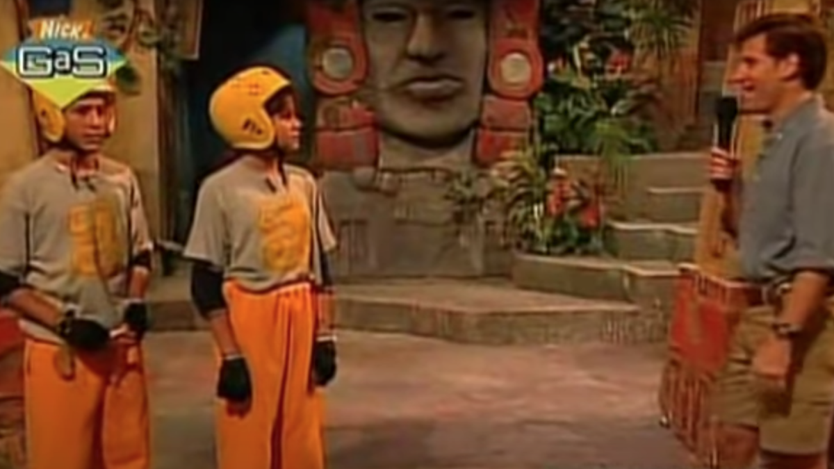 Screenshot of an episode of the Nickelodeon show Legends of the Hidden Temple shows to contestants and the show’s host standing ready for the final challenge in god Olmec’s temple