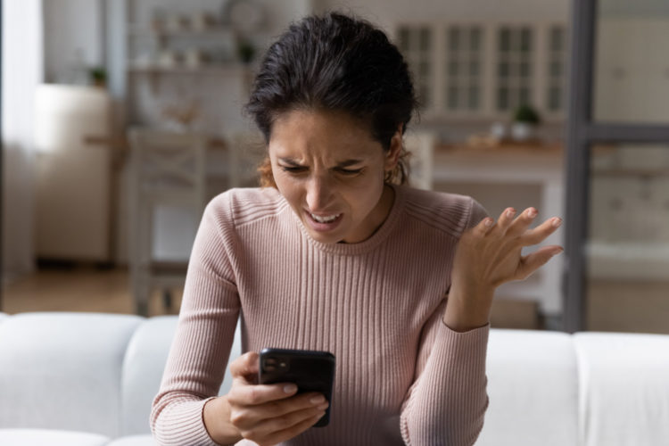 Woman expresses annoyance over text message or email on phone