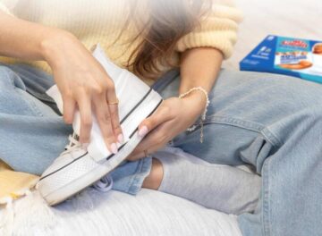woman uses Magic Eraser on white sneaker