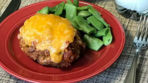 Taco meatloaf with cheese on a red plate