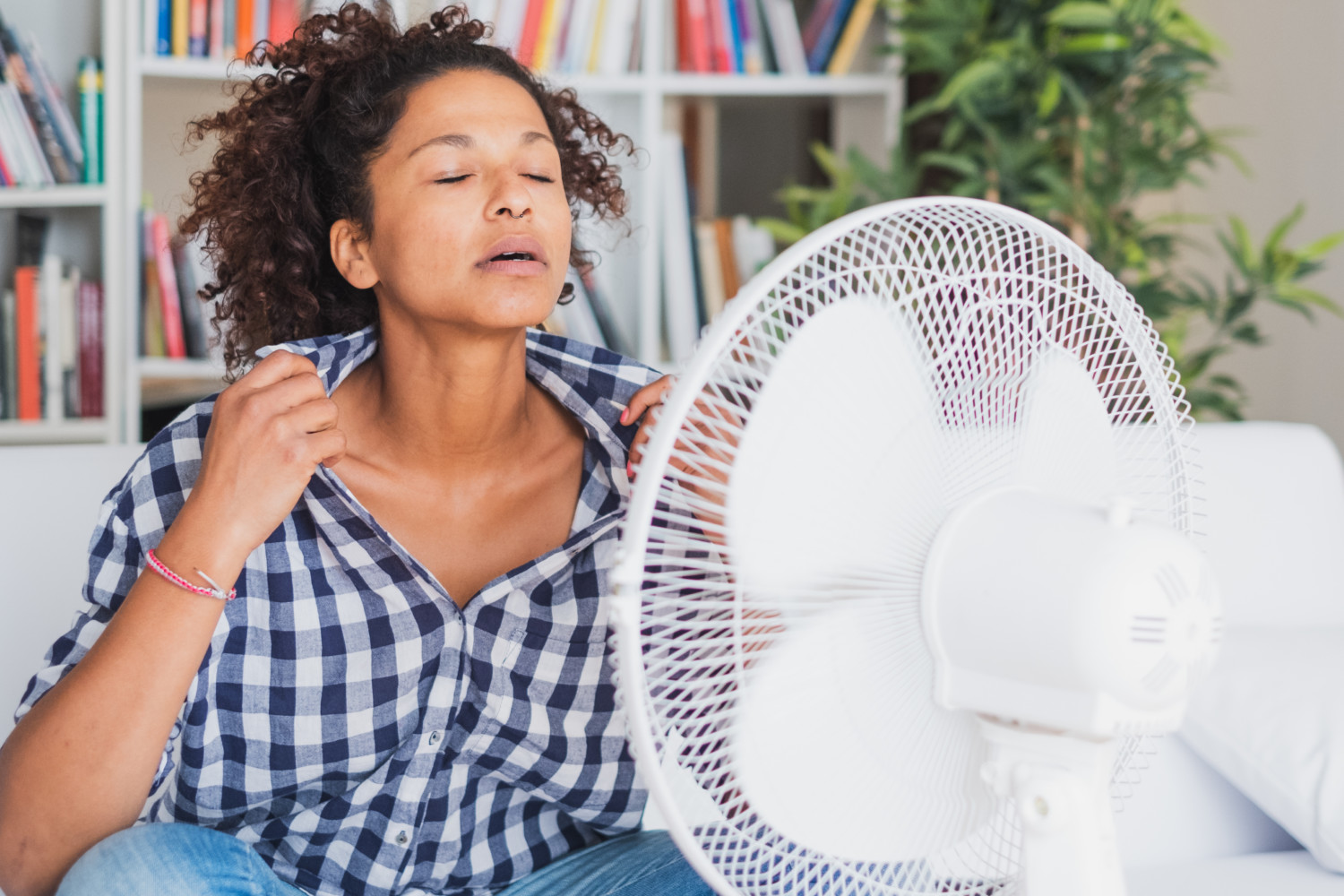 Woman uses fan to cool off in heat