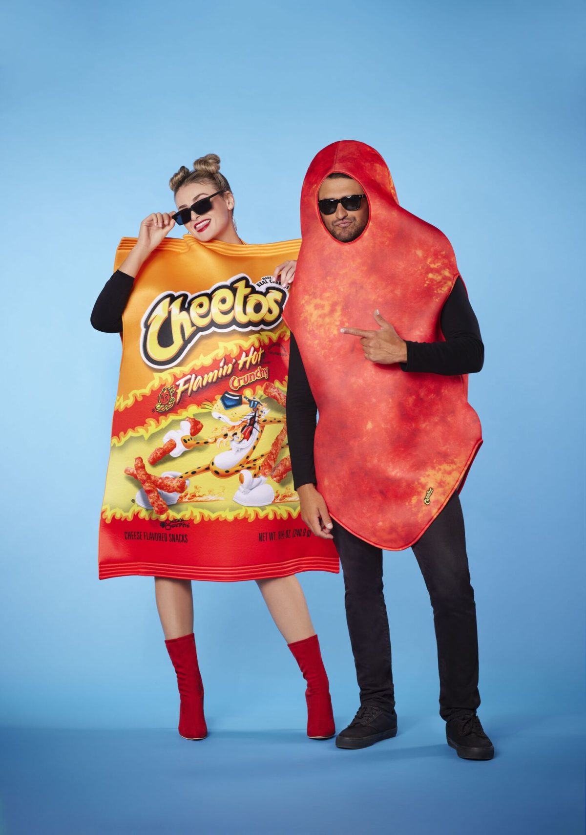 couple dressed for Halloween as Flamin' Hot Cheeto and Bag of Flamin' Hot Cheetos on blue background