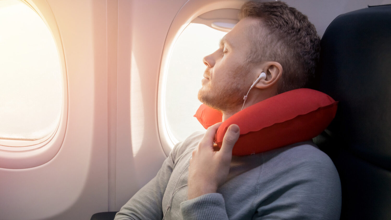 Airplane passenger uses travel pillow