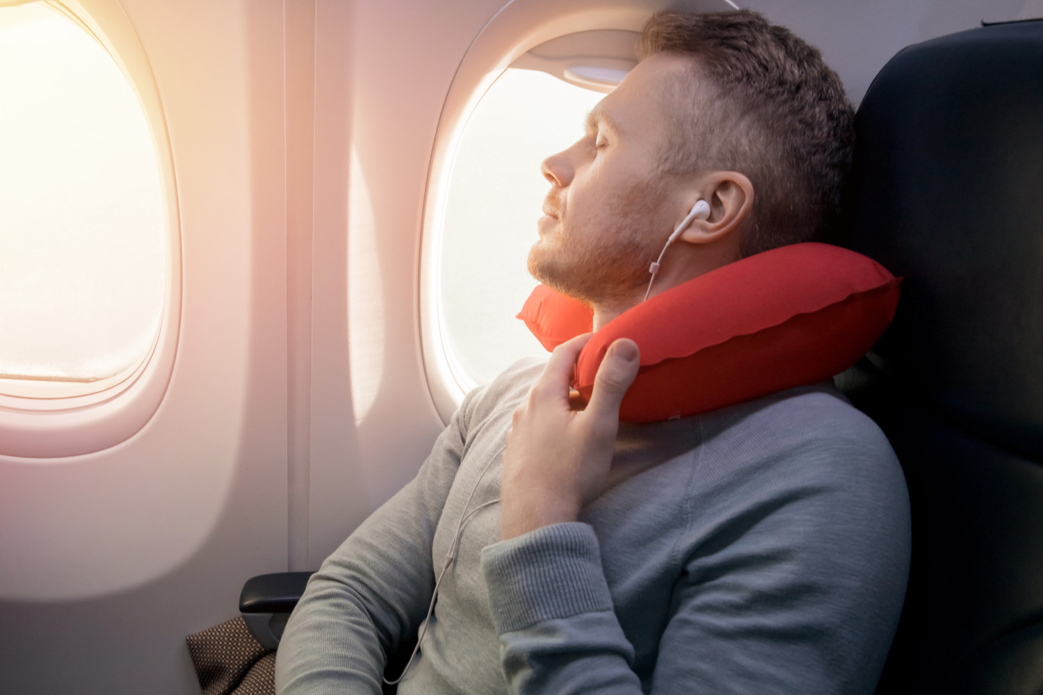 Airplane passenger uses travel pillow