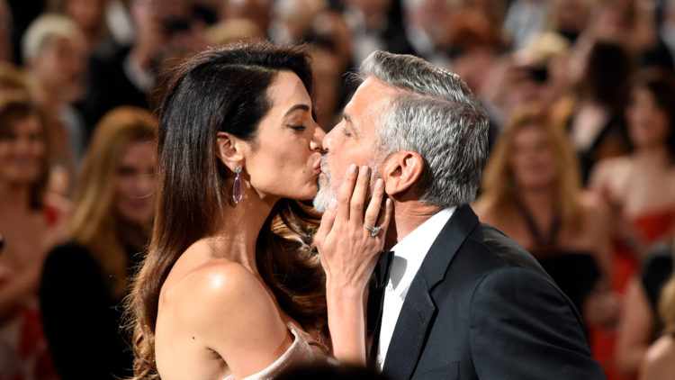 George Clooney and Amal Clooney kiss on red carpet in 2018
