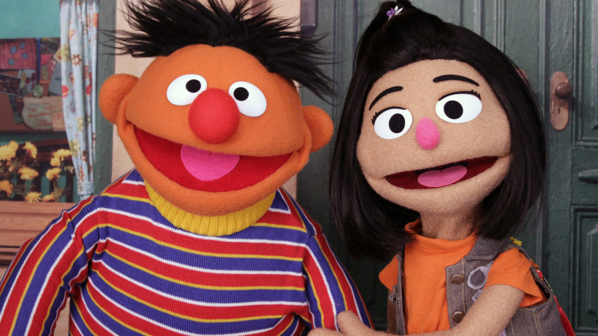 Ernie sits with new character Ji-Young, the first Asian-American muppet on Sesame Street