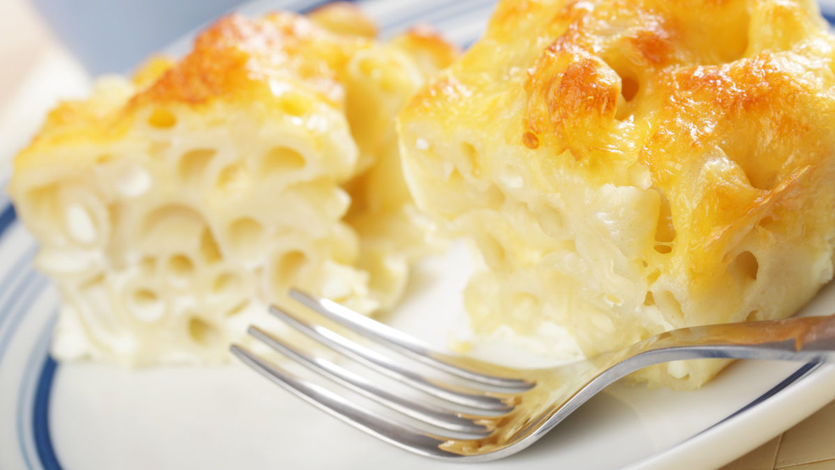 macaroni pie slice on a plate next to a fork