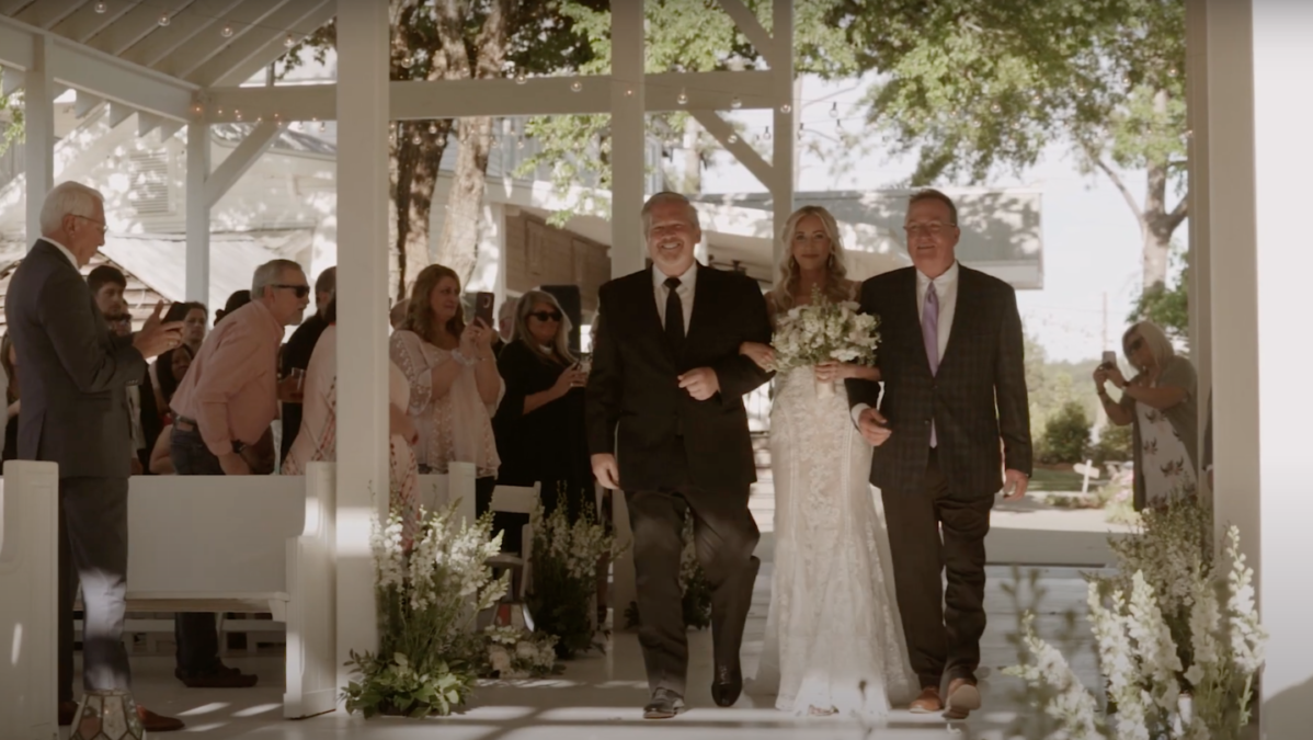 Kelsey Griffith is walked down the aisle by her father and stepfather at her wedding