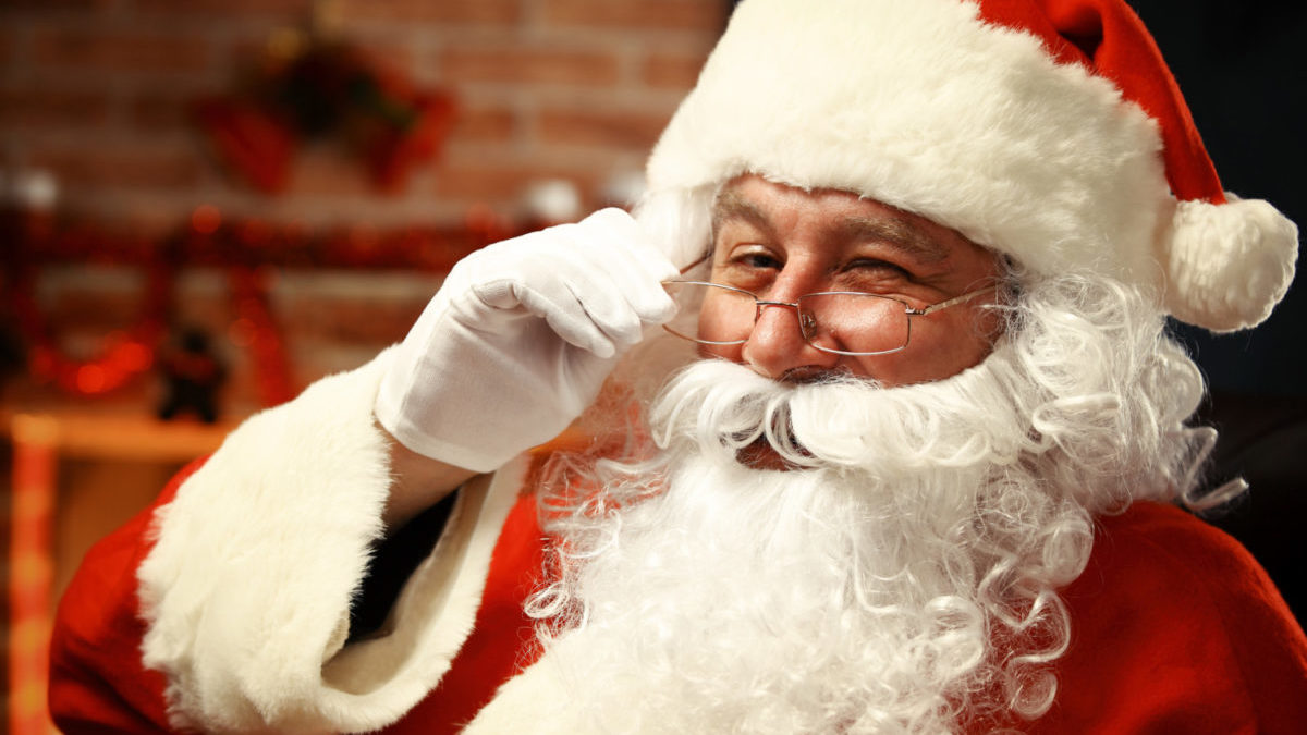 Portrait of happy Santa Claus holding Christmas letter in his ha