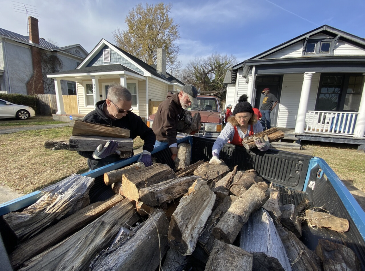 Volunteers with Project WARM haul wood for heat