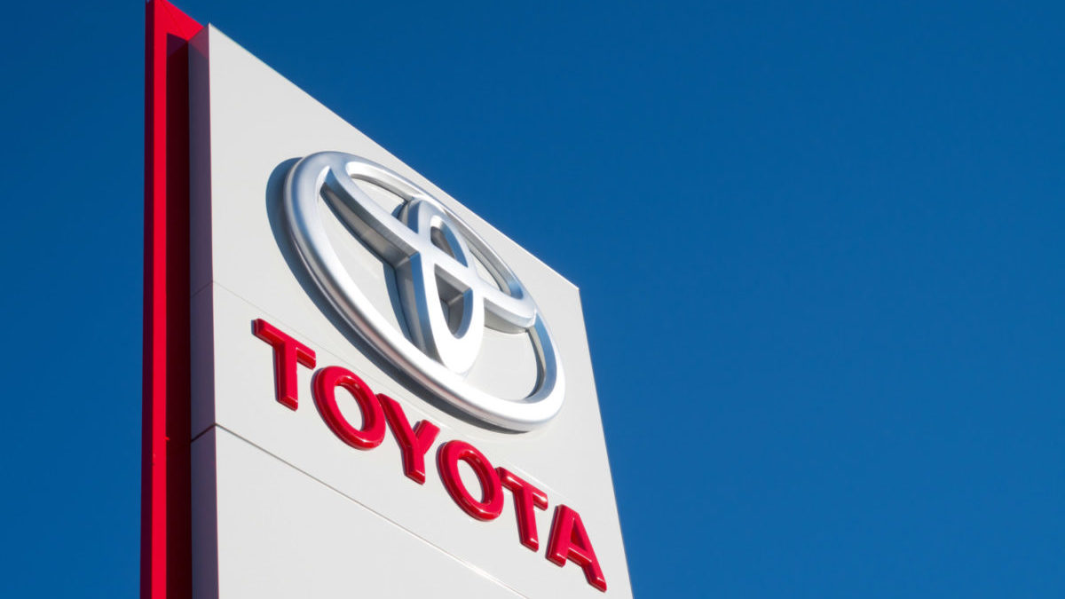 A Toyota dealership sign is shown against a blue sky.
