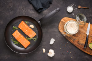 Salmon in frying pan with herbs