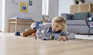 Child plays with Legos on floor