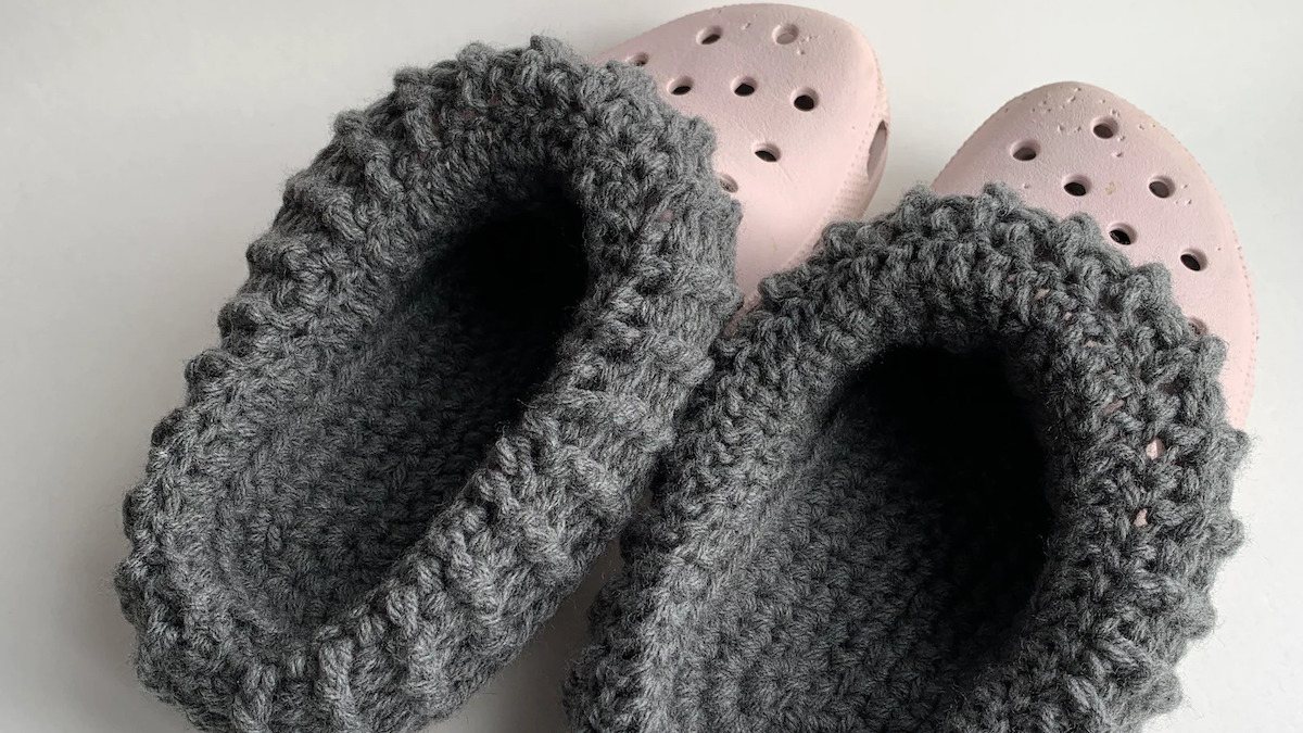 A pair of fuzzy crocheted liners are shown inside a pair of Crocs shoes.