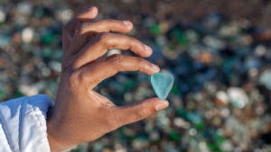 Person holds blue piece of sea glass
