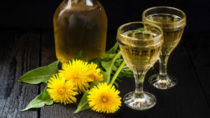 Homemade dandelion wine shown in a pair of glasses.