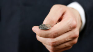 Coin in man's hand, ready for coin toss