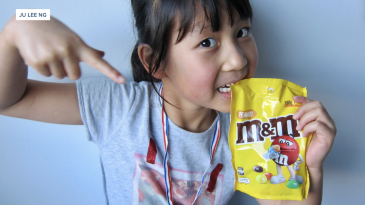 Stella Ng, who participated in the clinical trial, posed with a bag of the candy after results showed her peanut allergy had gone into remission.