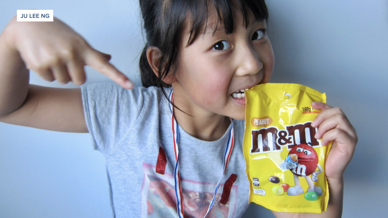 Stella Ng, who participated in the clinical trial, posed with a bag of the candy after results showed her peanut allergy had gone into remission.