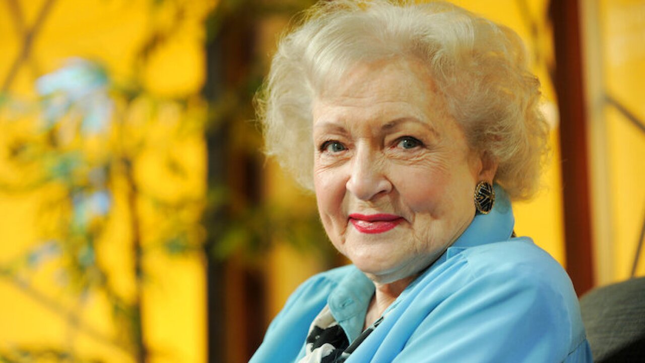 Betty White smiling against yellow background