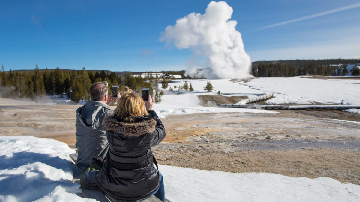 Visitors Filming Old Faithful from Geyser Hill at Yellowstone National Park.