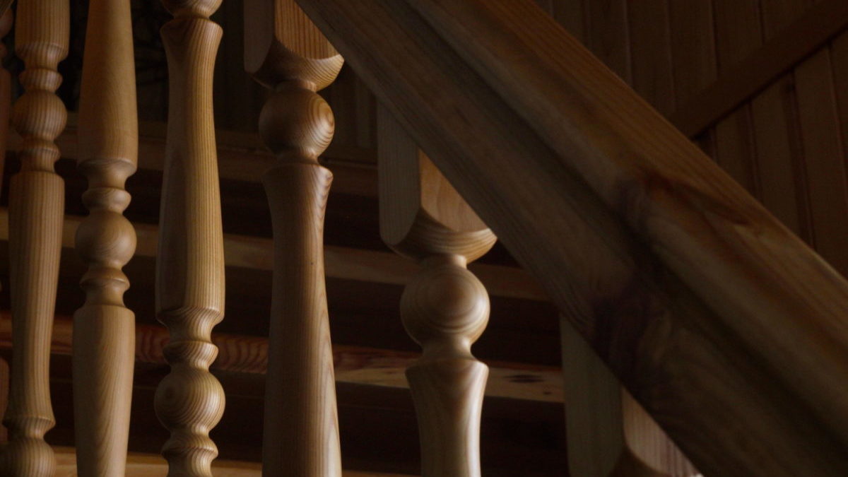 An upside-down baluster on a wooden staircase bannister.