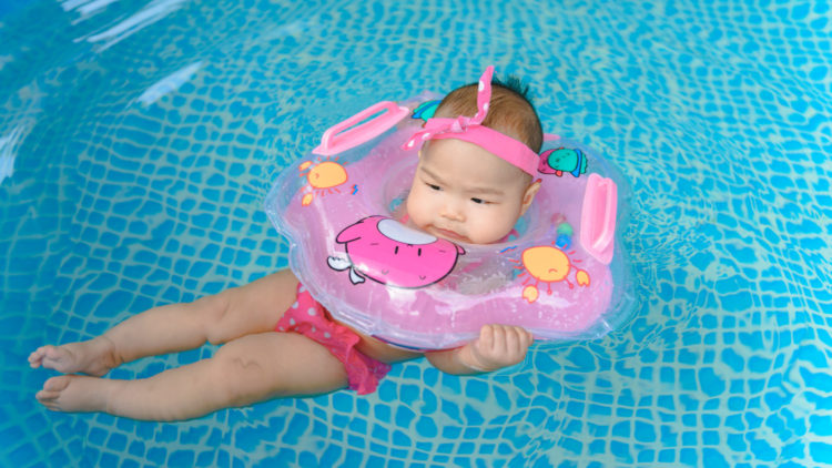 Girl uses baby neck float in pool