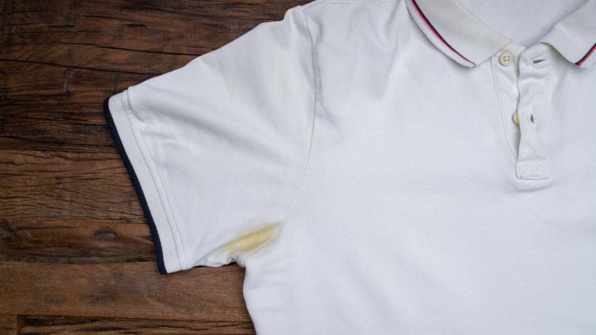 A yellow underarm sweat stain is shown on a white shirt.