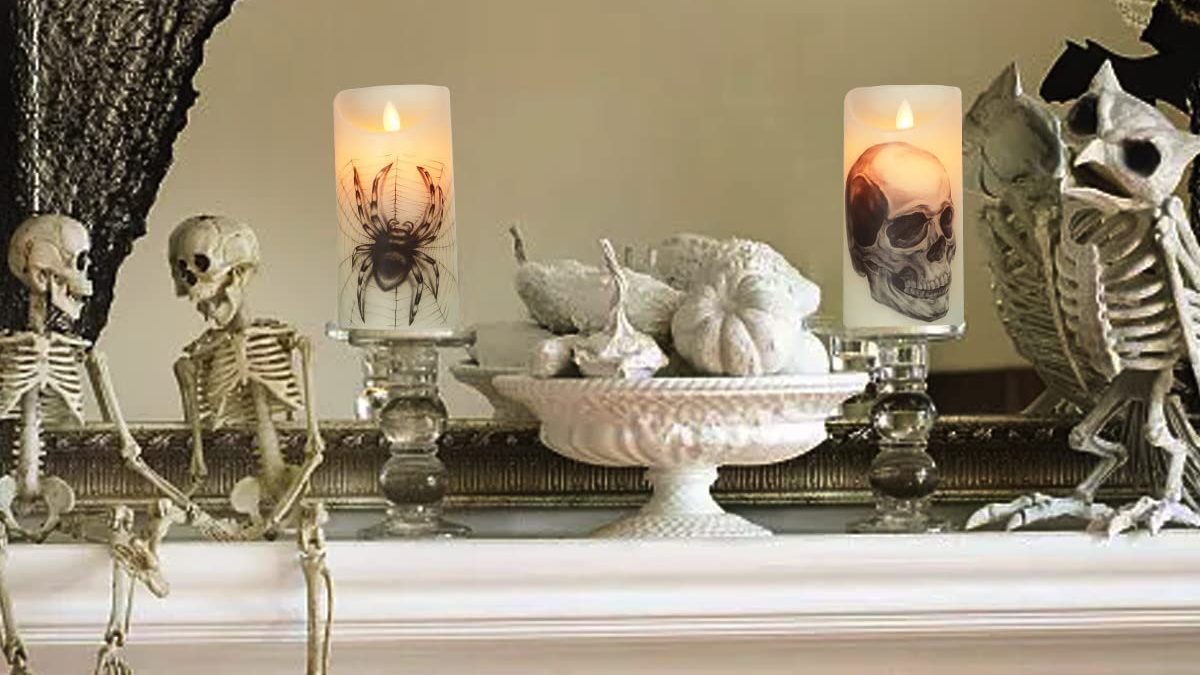 Halloween candles are lit on a mantle for autumn.