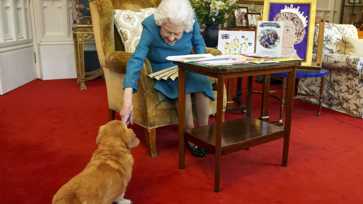 Britain's Queen Elizabeth II, joined by one of her dogs.