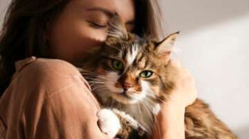 Woman snuggles with fluffy cat